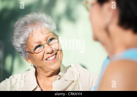 Aktiven Ruhestand, zwei ältere Freundinnen reden auf Bank im öffentlichen park Stockfoto