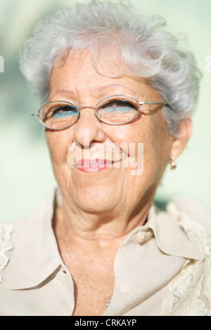 Porträt von senior kaukasischen Frau mit Brille, Blick in die Kamera und lächelnd Stockfoto