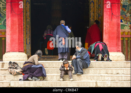 Menschen vor Ort und gehen in den Haupteingang des Sutra Prunksaal des Klosters Labrang in Xiahe Pilger. Stockfoto