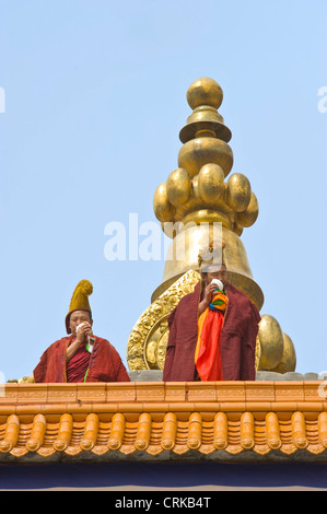 2 tibetische buddhistische Mönche (Geluk oder gelben Hut) auf der Oberseite der Prunksaal Sutra im Kloster Labrang in Xiahe "Berufung zu beten Stockfoto