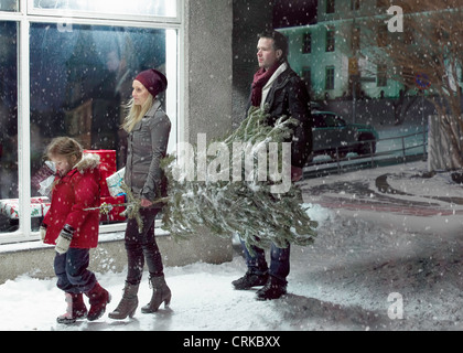 Familie mit Weihnachtsbaum im Schnee Stockfoto