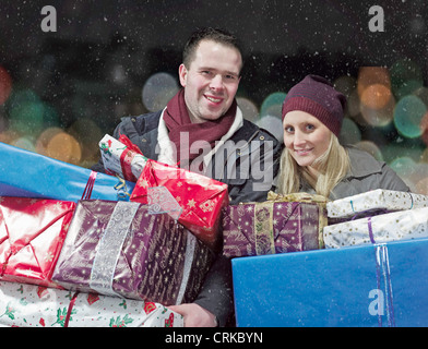 Paar mit Weihnachtsgeschenke im Schnee Stockfoto