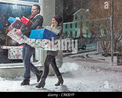 Paar mit Weihnachtsgeschenke im Schnee Stockfoto