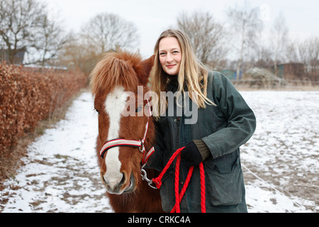 Frau Walking Horse auf verschneiten Weg Stockfoto