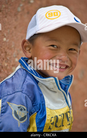 Ein frecher lächelnder tibetische chinesische junge mit Schleim aus der Nase dribbling posiert für die Kamera. Stockfoto