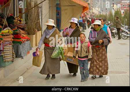 Eine Gruppe von lokalen chinesischen tibetischen Frauen in traditioneller Kleidung einkaufen im Zentrum von Xiahe gekleidet. Stockfoto