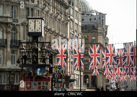 Union Jack-Flaggen hängen über Coventry Street, hinter der berühmten Schweizer Uhr in Leicester Square. Bild von Julie Edwards Stockfoto