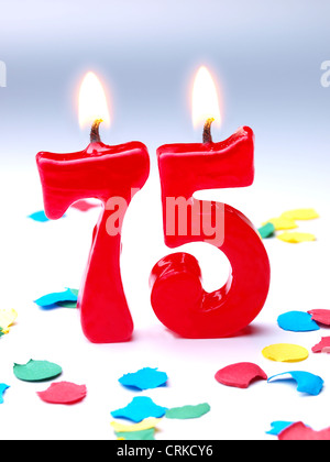 Nummer 75 Geburtstag Kerze gegen einen hellen Lichtern und blauer