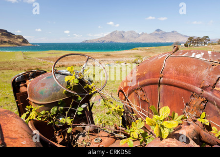 Eine alte Traktor verlassen bei der Cleadale auf der Insel Eigg, mit Blick auf die Isle of Rum, Schottland, UK. Stockfoto