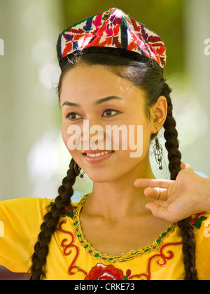 Porträt eines lächelnden Uyghur chinesischen Mädchens in Tracht. Stockfoto