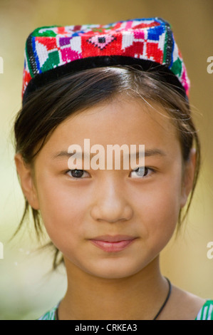 Porträt eines lächelnden Uyghur chinesischen Mädchens in Tracht. Stockfoto