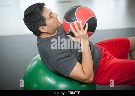 Mann mit Gymnastikball im Fitness-Studio Stockfoto