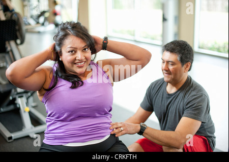 Frau mit Trainer im Fitness-Studio Stockfoto