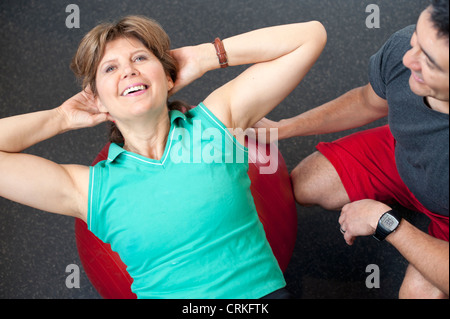 Frau mit Trainer im Fitness-Studio Stockfoto