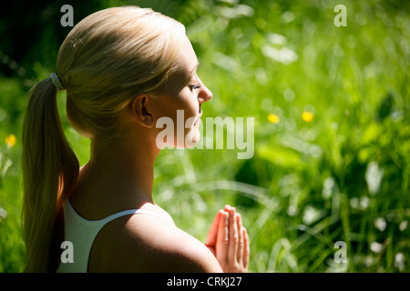 Eine junge Frau Yoga zu praktizieren, die Hände im Gebet position Stockfoto