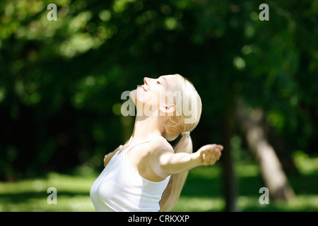 Eine junge Frau, die außerhalb stehen, die Arme ausgestreckt, Nahaufnahme Stockfoto