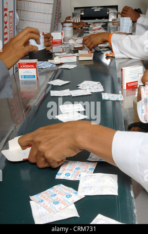 Pharmazeutische Fabrikarbeiter packen Medizin in Verpackung. Stockfoto