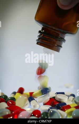 Eine Auswahl an farbigen Pillen und Kapseln aus einer Flasche gießen. Stockfoto