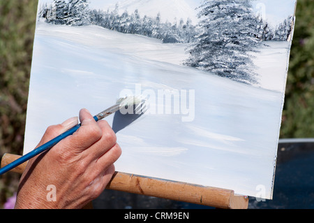 Person Künstler Malerei mit Pinsel auf einer Leinwand auf einer Staffelei Stockfoto