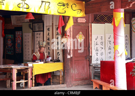 LIJIANG, CHINA - 8. Dezember 2010: Ein nicht identifizierter Naxi ethnischen Priester Poren über seine Bücher an die Dongba Valley Cultural Village Stockfoto