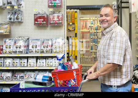 Seite Ansicht Porträt ein glücklich reifer Mann mit Einkaufskorb im Baumarkt Stockfoto