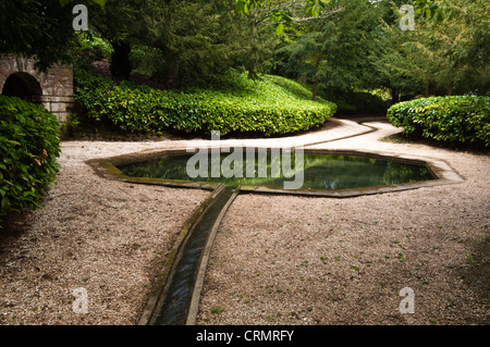 Die achteckige kaltes Bad konzipiert zum Baden wird durch klares Quellwasser entlang der ursprünglichen Stein ausgekleidet Rill Rousham House, Oxfordshire, England zugeführt. Stockfoto