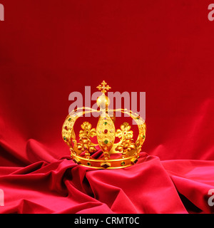 Goldene Krone mit Diamanten und Juwelen auf Granatsamt Stockfoto