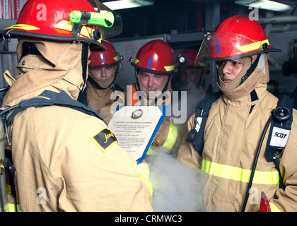 Damage Controlman 3. Klasse Luis Garza, rechts, wird ehrenvoll von der Marine entlassen, bevor er an Bord des Lenkraketen-Zerstörers USS James E. Williams (DDG 95) wieder aufgenommen wird. James E. Williams ist im Verantwortungsbereich der 5. US-Flotte im Rahmen der Operation Enduring Freedom im Einsatz und führt maritime Sicherheitsoperationen, Sicherheitskooperationen und Unterstützungsmissionen durch. Stockfoto