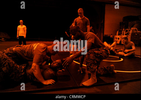 Die Marines nehmen am Marine Corps Martial Arts Program (MCMAP) in der Hangar Bay an Bord des Flugzeugträgers USS Nimitz (CVN 68) Teil. Nimitz führt derzeit die Ausbildung von Spediteur-Trägern durch, um sich auf den Rim of the Pacific (RIMPAC) 2012 vorzubereiten, die größte internationale maritime Übung der worldÕs Stockfoto