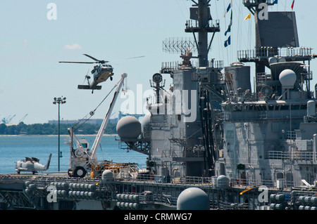 MH-60S Knight Hawk Hubschrauber landet auf dem Flugdeck des amphibischen Sturmschiffs USS Kearsarge (LHD 3) während der Durchführung von Flugoperationen im Hafen. Stockfoto