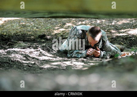 U.S. Army Sgt. Adam McQuiston, Fort Leonard Wood, Mo., Bohrlehrer, kriecht tief unter einem Hindernis auf dem Confidence Course in Fort Eustis, Virginia, 27. Juni 2012, als Teil des jährlichen Drill Sergeant of the Year Wettbewerbs, der von Initial Military Training, U.S. Army Training und Doctrine Command ausgerichtet wird. Während des Kurses mussten die Teilnehmer Dinge wie Tiefkrabbeln, Kreuz-Affenbarren, Wände klettern und Sprunggräben tun. Stockfoto