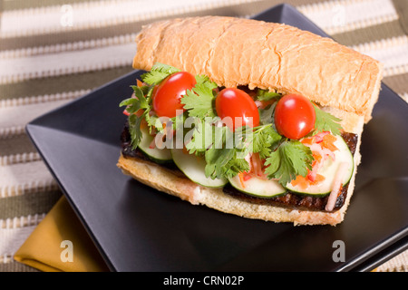 Vegane Banh Mi Sandwich mit Tomaten, Krautsalat, Gurkenscheiben und Koriander Stockfoto