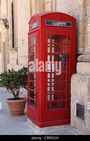 Traditionelles englisches rote Telefon Stand stehend durch die Wand in Malta Stockfoto
