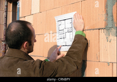 Man studiert einen Plan auf der Baustelle Stockfoto