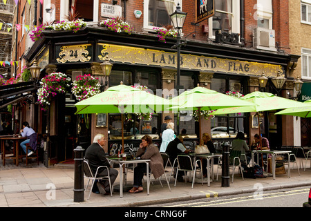 Menschen sitzen unter den Sonnenschirmen vor dem Lamm und Fahne Pub in der James Street. Stockfoto