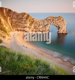 Menschen am Sandstrand von Durdle Door, ein natürlicher Kalkstein-Bogen in der Nähe von Lulworth Cove, Teil der UNESCO-Jurassic Coast. Stockfoto