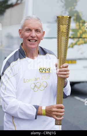 Ein Läufer mit seinem London 2012 Olympische Fackel während des Fackellaufs in Großbritannien Stockfoto