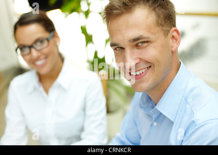 Porträt von ein Business-Team, Kerl, in der Front, hinter ihm sitzt-girl Stockfoto