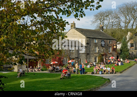 Touristen Entspannung außerhalb der Lister Arme, ein Gasthaus an der Unterseite von Malham Cove. Stockfoto
