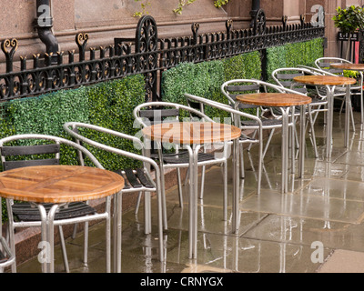 Café Tische draußen im Regen auf einer Straße in Edinburgh, Schottland. Stockfoto