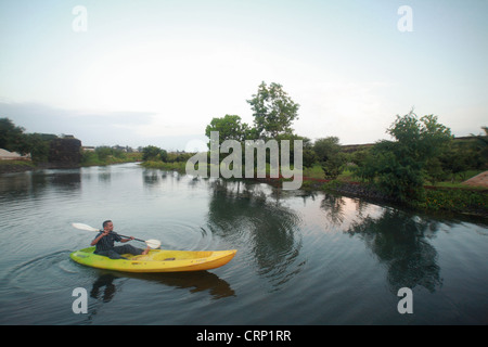 Mann auf Kayak in stillem Wasser. Kanufahren ist eine outdoor-Aktivität, die eine besondere Art von Kanu beinhaltet. Stockfoto