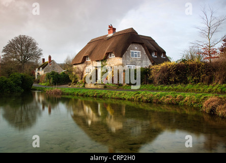 Blick über einen Teich in Richtung strohgedeckten Hütten am Sherrington. Stockfoto