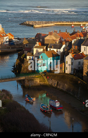 Angelboote/Fischerboote im geschützten Hafen von Staithes in der Abenddämmerung. Stockfoto