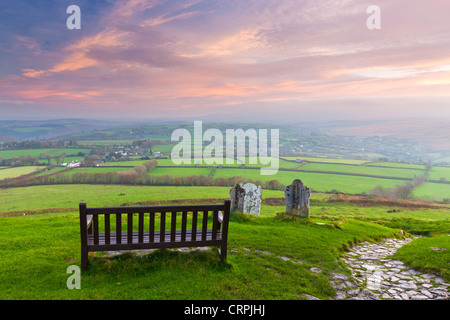 Blick von einer Bank von der Kirche St. Michael auf Brent Tor über die ländliche Landschaft des Dartmoor. Stockfoto