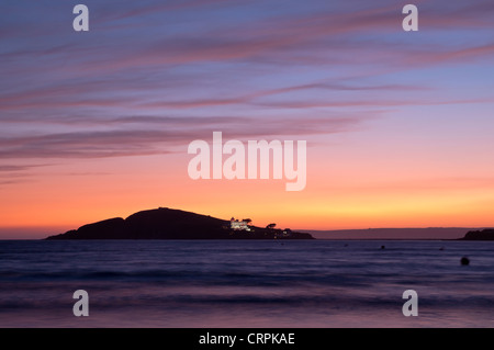 Blick vom Bantham Strand in Richtung Burgh Island Silhouette bei Sonnenuntergang. Stockfoto