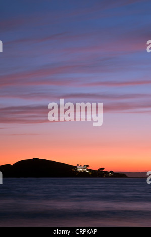 Blick vom Bantham Strand in Richtung Burgh Island Silhouette bei Sonnenuntergang. Stockfoto