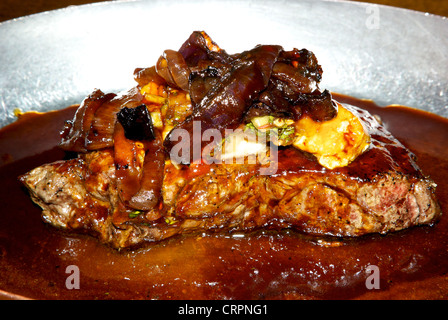 Gegrillte Prime New York Rindfleisch Steak au jus karamellisierten Zwiebeln jam enthärtetes Blauschimmelkäse Stockfoto