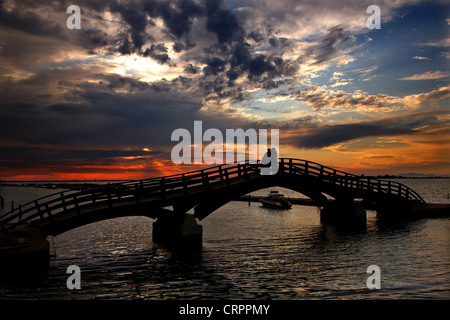 Sonnenuntergang in Lefkas (Lefkada) Stadt, in der kleinen Marina für die Fischerboote mit schöne Holzbrücke. Ionische Inseln, Griechenland. Stockfoto