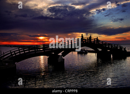 Sonnenuntergang in Lefkas (Lefkada) Stadt, in der kleinen Marina für die Fischerboote mit schöne Holzbrücke. Ionische Inseln, Griechenland. Stockfoto