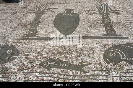 Ostia Antica. Platz der Gilden oder Konzerne. Mosaik-Darstellung einer Amphora zwischen zwei Palmen und drei Fische. Stockfoto